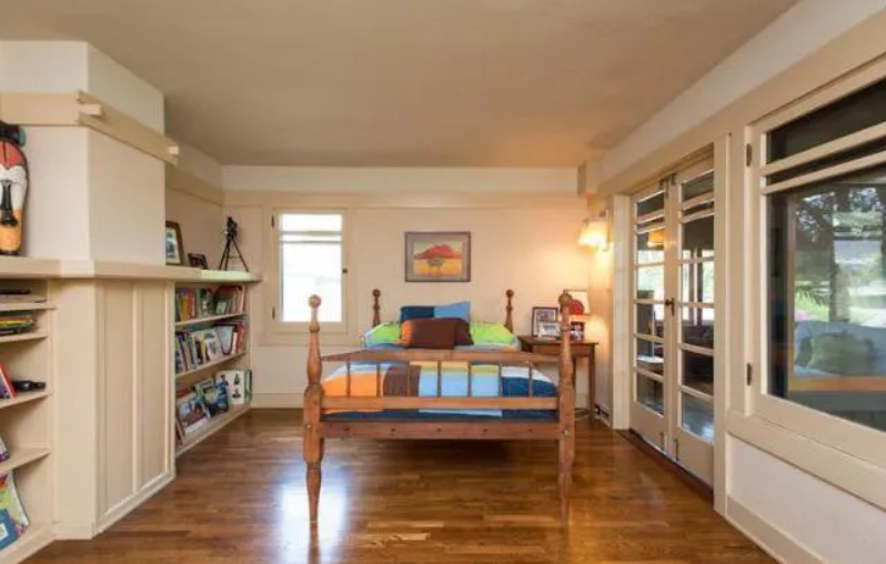 A bedroom in the Louise T. Halsted House with tan-colored walls and white trim.