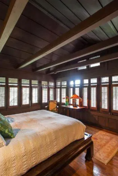 A bedroom in the Louise T. Halsted House with extensive natural wood paneling on the walls and a built-in dresser.