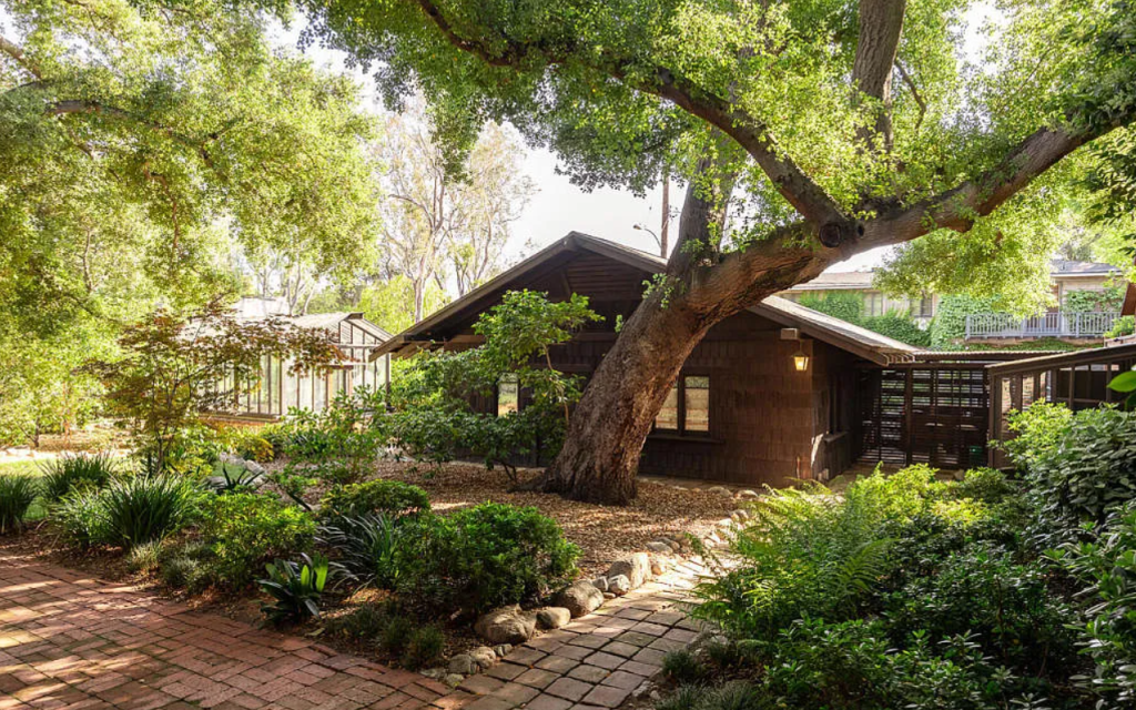 Close-up of backyard garage at the Louise C. Bentz House with Craftsman details, wood siding, and surrounding plantings