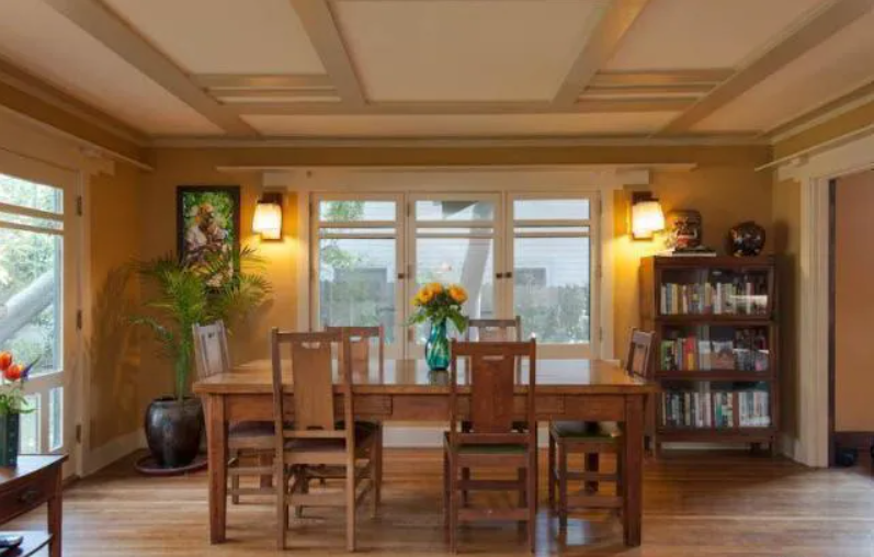 The dining room of the Louise T. Halsted House, with wood paneling and a view through open doors to the living room.