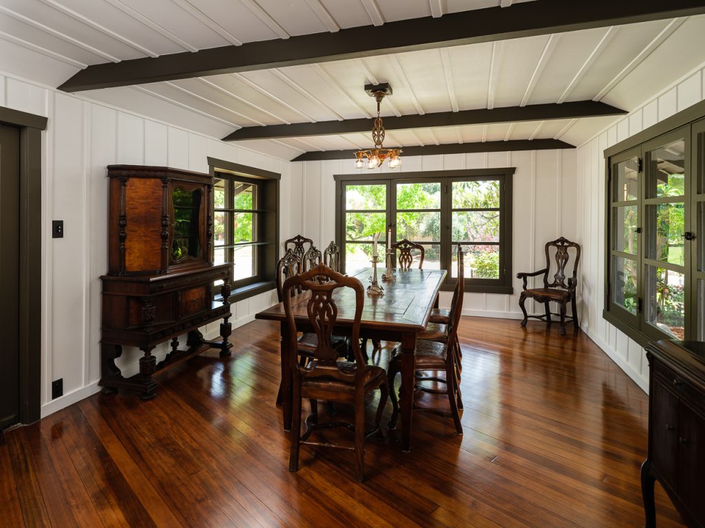 Gallery of two images showing the Edgar W. Camp House dining room: a contemporary view with exposed beam ceiling, white board-and-batten walls, and period furnishings, and a historic black and white photograph showing the original dark wood paneling, decorative built-ins, and Arts and Crafts furnishings.