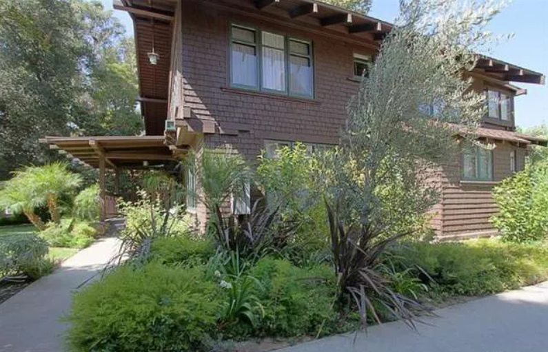 Gallery of four contemporary photographs showing the Josephine van Rossem House No. 2 (1904) by Greene & Greene, including driveway approach view, front door entrance detail, full front elevation, and covered front porch, demonstrating the California House concept with cedar shingle siding, cobblestone foundation, and mature landscape integration in Pasadena, California.