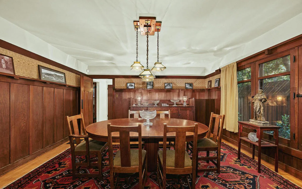 Dining room of the Louise C. Bentz House with wood furniture, built-in sideboard, chandelier, and large windows
