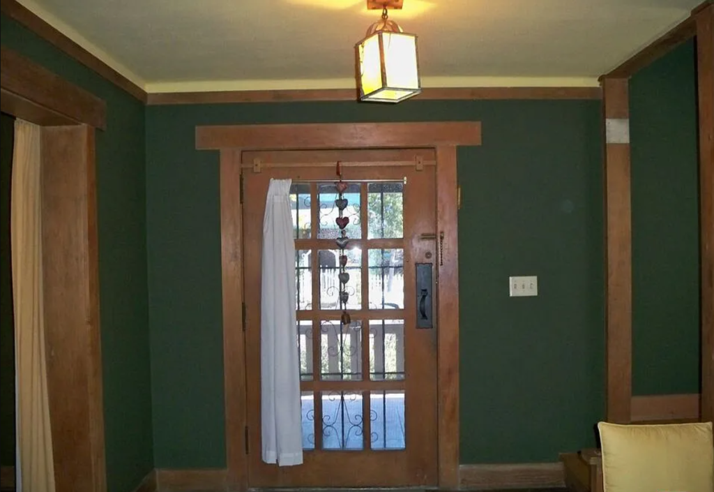 A close-up photograph of the interior of the front door of the Miss Lucy E. Wheeler House, showing the custom hardware and art glass.