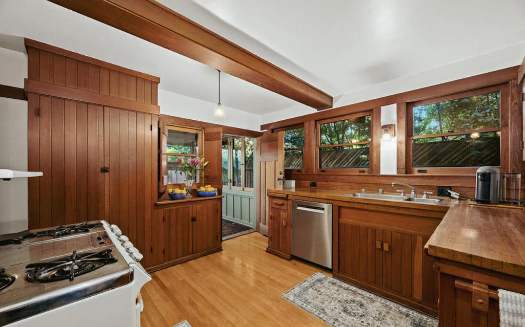 Kitchen of the Louise C. Bentz House with white cabinetry, marble countertops, professional appliances, and center island