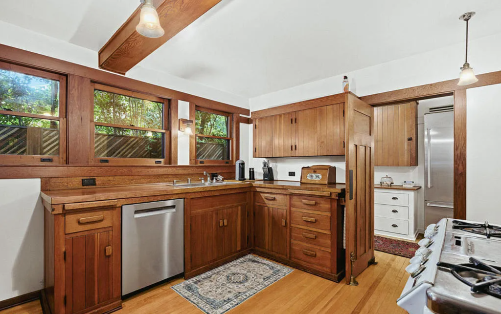 Alternate kitchen view of the Louise C. Bentz House showing white cabinetry, breakfast nook, and professional range