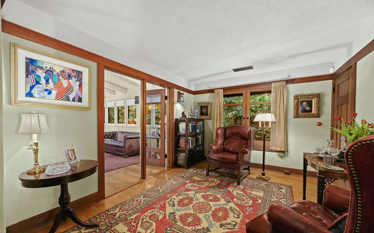An upstairs sitting room in the Louise C. Bentz House, a quiet well-proportioned room with wood trim and windows shaded by the deep eaves, simply furnished, the daylight diffused and even