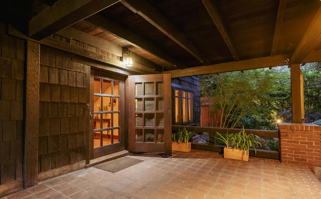 Twilight patio view of the Louise C. Bentz House with outdoor seating, pergola, and illuminated landscape lighting