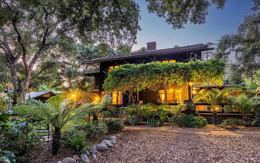 Alternate twilight sideyard view of the Louise C. Bentz House with illuminated windows, landscaping, and architectural details