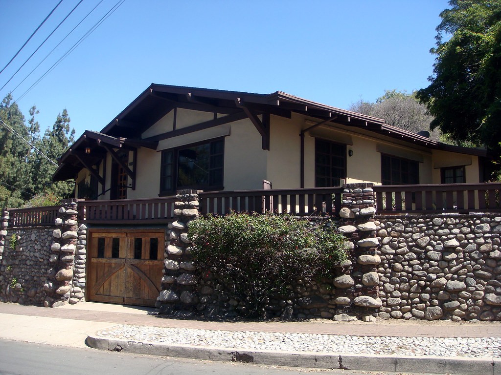Street view of Martha, Violet and Jane White House highlighting boulder stone retaining walls, wooden balustrade, and landscape integration by Greene & Greene, 1903.