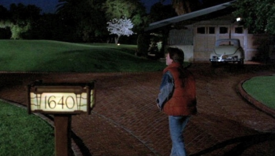 Night scene from the 1985 film "Back to the Future" showing Marty McFly standing in the driveway of the Gamble House, which served as Doc Brown's home at 1640 Riverside Drive, with the garage visible in the background