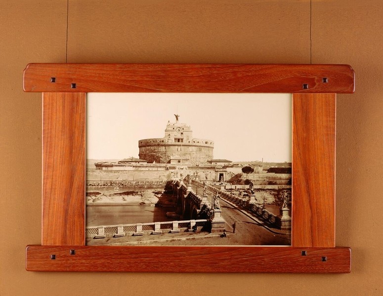 Cedar picture frame with Arts and Crafts joinery holding artwork depicting Roman architectural scene. The frame demonstrates Greene and Greene's use of varied woods beyond mahogany, with visible construction details and proportions suited to the specific artwork.