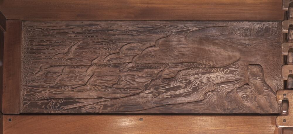 Beach scene frieze panel showing weathered tree stump on shoreline with waves and seagulls. The composition captures California coastal character with attention to natural forms and atmospheric effects, rendered in subdued, naturalistic palette.