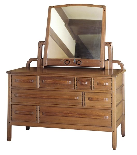 Greene and Greene designed eight-drawer dresser from the Gamble House crafted by Peter Hall Manufacturing Company in Honduras mahogany, featuring a large tilting mirror with mahogany frame and decorative silver inlay at the center, eight drawers of varying sizes arranged asymmetrically with cloud-lift copper pulls, square ebony pegs securing all joinery, tapered legs, and the characteristic rounded edges and handcrafted details that demonstrate the brothers' furniture design philosophy