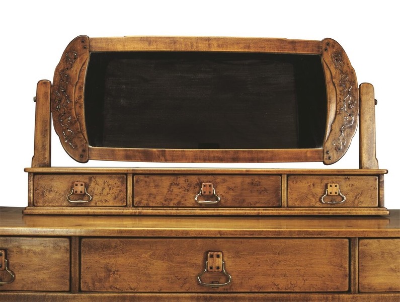 Detail view of the upper section of a Greene and Greene designed dressing table from the Gamble House crafted by Peter Hall Manufacturing Company in Honduras mahogany and bird's-eye maple, showing a tilting mirror with figured maple frame decorated with silver and abalone shell inlay depicting stylized vine motifs on the curved side supports, three small drawers with figured maple fronts and cloud-lift copper pulls with decorative escutcheons, and square ebony pegs throughout, demonstrating the meticulous attention to decorative detail applied even to small functional elements
