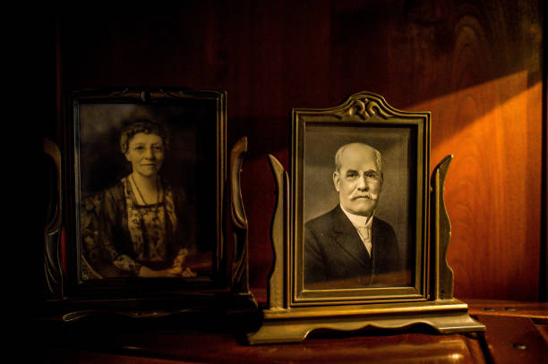 Portrait photographs of David Berry Gamble (white hair and mustache in gilt frame) and Mary Huggins Gamble (in ornate dress in dark frame) from their later years, displayed on mahogany surface, commemorating the original owners