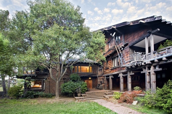 Thorsen House backyard with timber bridge connecting to garage, clinker brick terraces, and sheltered garden courtyard