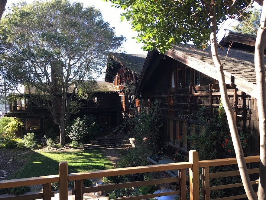 East side of Thorsen House property showing timber pergola, clinker brick chimney, and sheltered rear terrace area