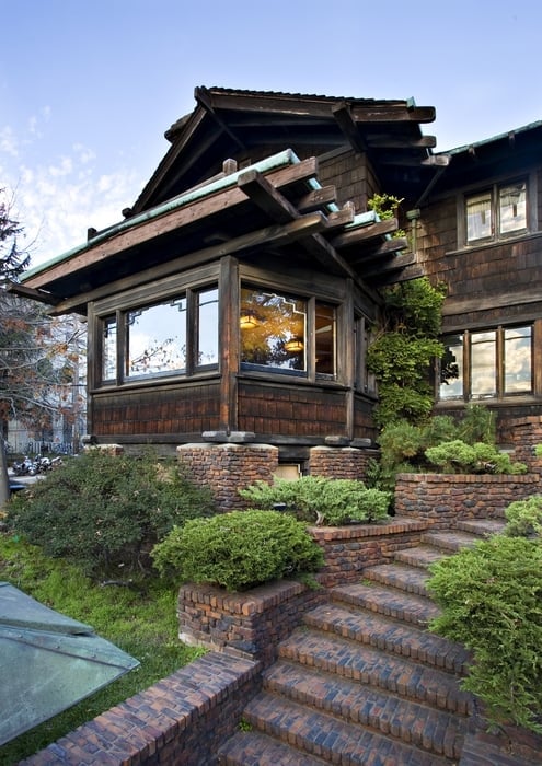 Northwest view of Thorsen House entrance with clinker brick stairs, terraced landscaping, and timber-framed facade