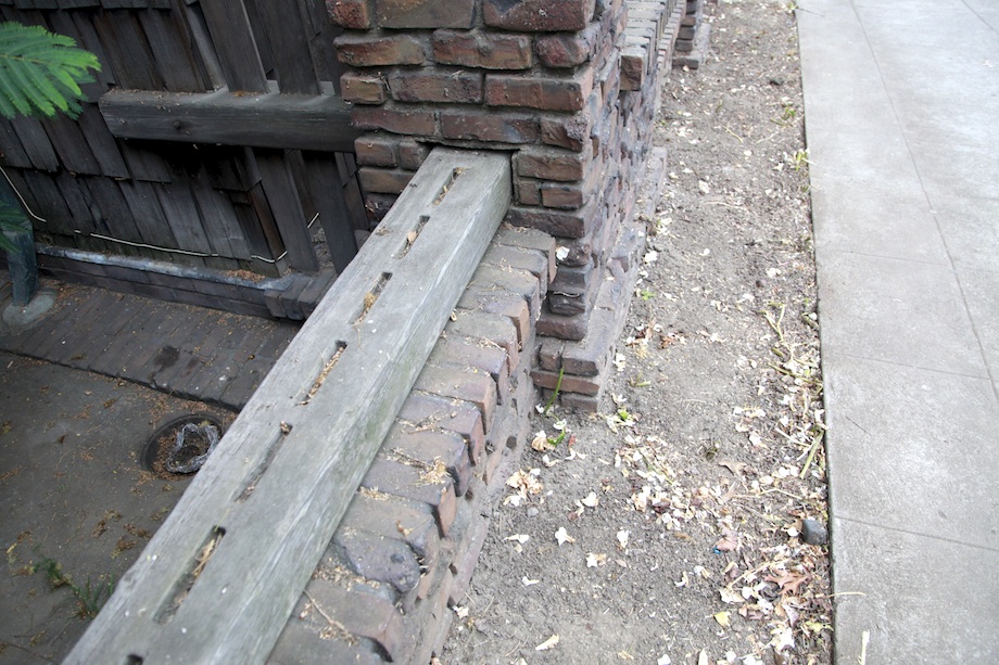 Weathered fence timber with exposed mortise joints and ebony pegs, showing Arts & Crafts construction techniques