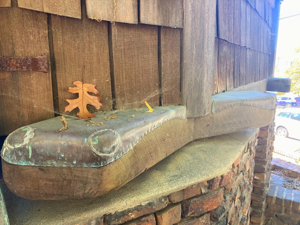 Foundation detail with copper protective flashing, timber beam, clinker brick, and wood shingle siding