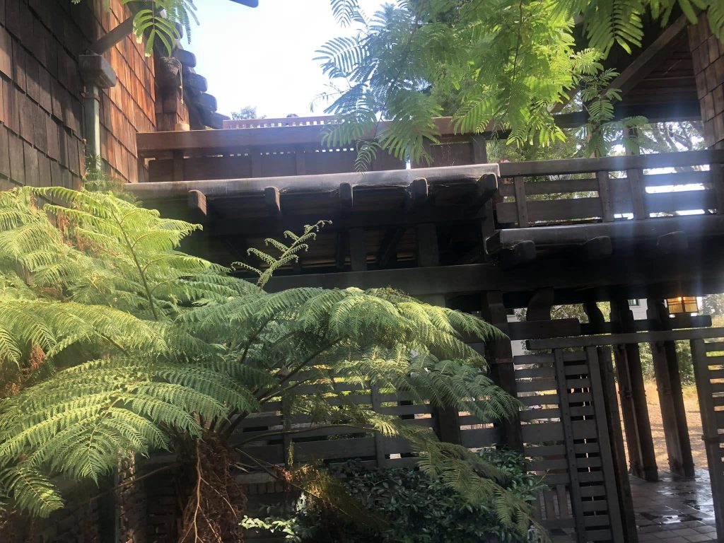 Gate entrance to Thorsen House rear terrace with timber posts, brick pavers, and Arts & Crafts architectural details