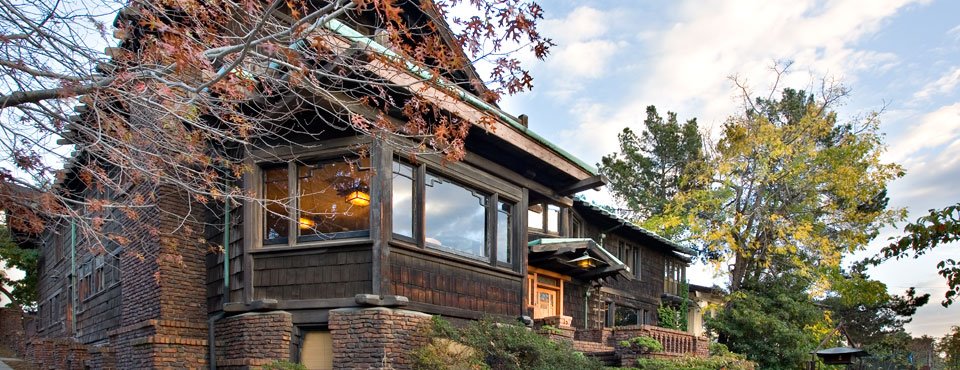 Panoramic northwest view of Thorsen House with clinker brick base, wood shingles, dramatic rooflines, and autumn trees