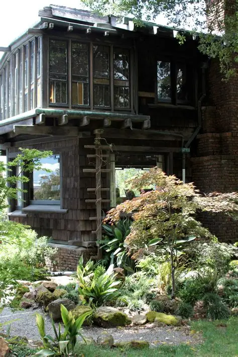 Southeast corner of Thorsen House showing timber bridge, clinker brick piers, bay windows, and lush garden landscaping