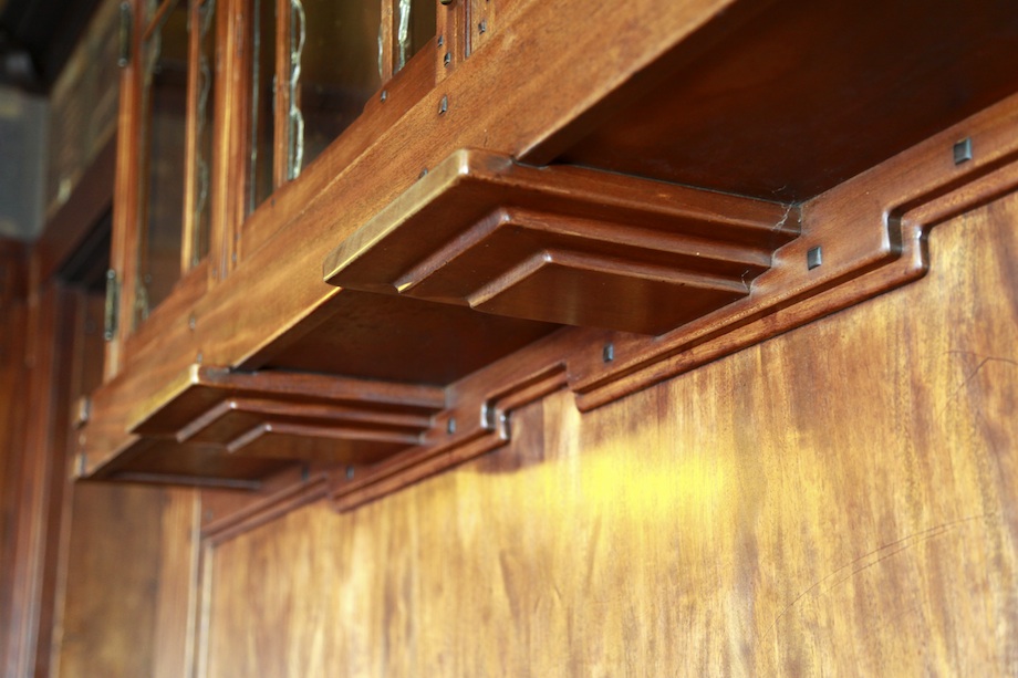 Detail of Thorsen House dining room cabinet corbels with stepped mahogany brackets, ebony pegs, and Arts & Crafts joinery