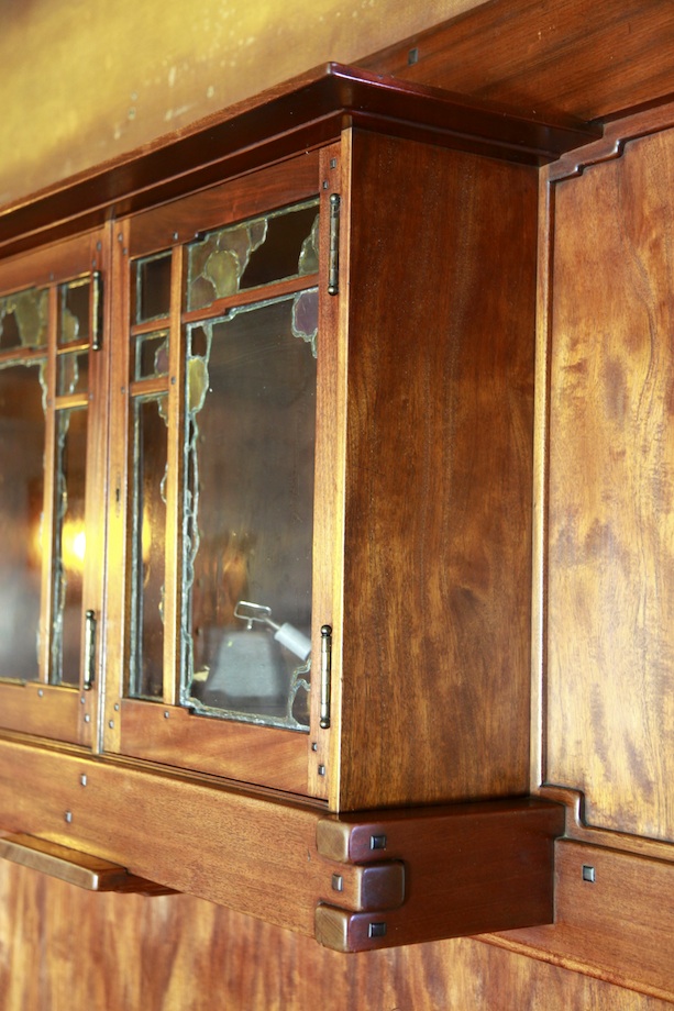 Thorsen House dining room cabinet with glass doors, cloud lift art glass, stepped corbels, and mahogany craftsmanship