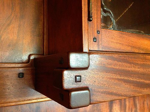 Close-up of Thorsen House dining room cabinet joinery showing interlocking corbels, ebony pegs, and precise woodworking