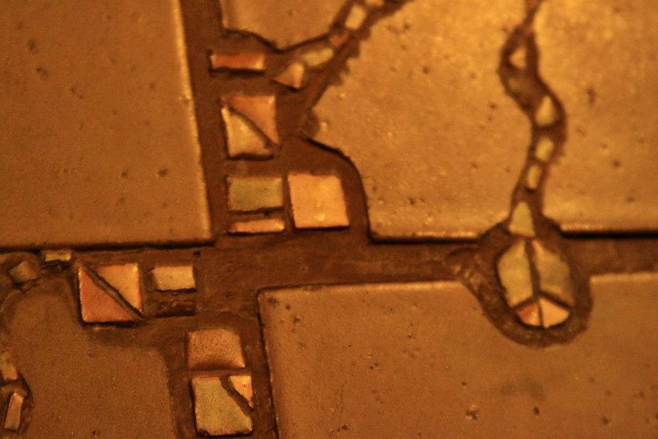 Close-up of Thorsen House dining room fireplace tile showing geometric pattern with ebony inlay and Arts & Crafts design
