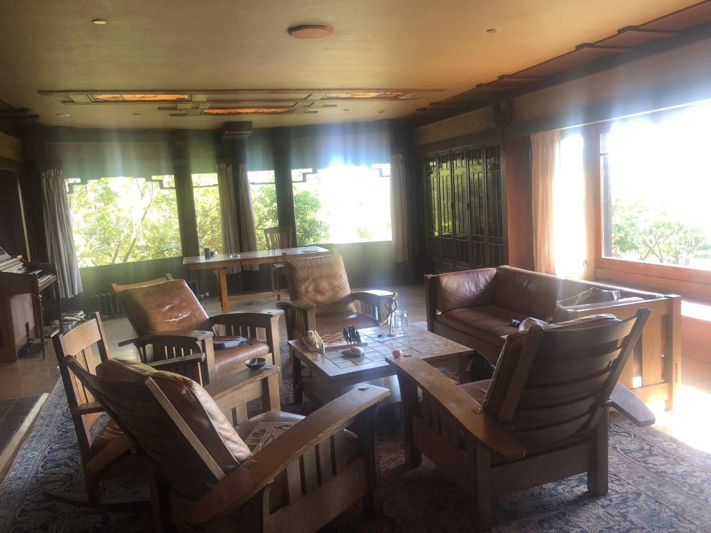 Thorsen House living room with leather seating, recessed ceiling lights, plate glass windows, and Arts & Crafts details
