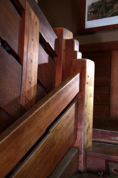 Thorsen House stairway landing newel post with chunky proportions, ebony inlay, and mahogany construction