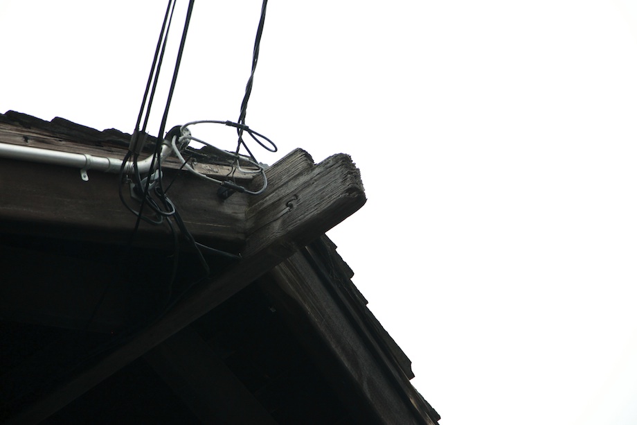 Deteriorated ridge beam showing rot damage with temporary wire supports, documenting preservation challenges