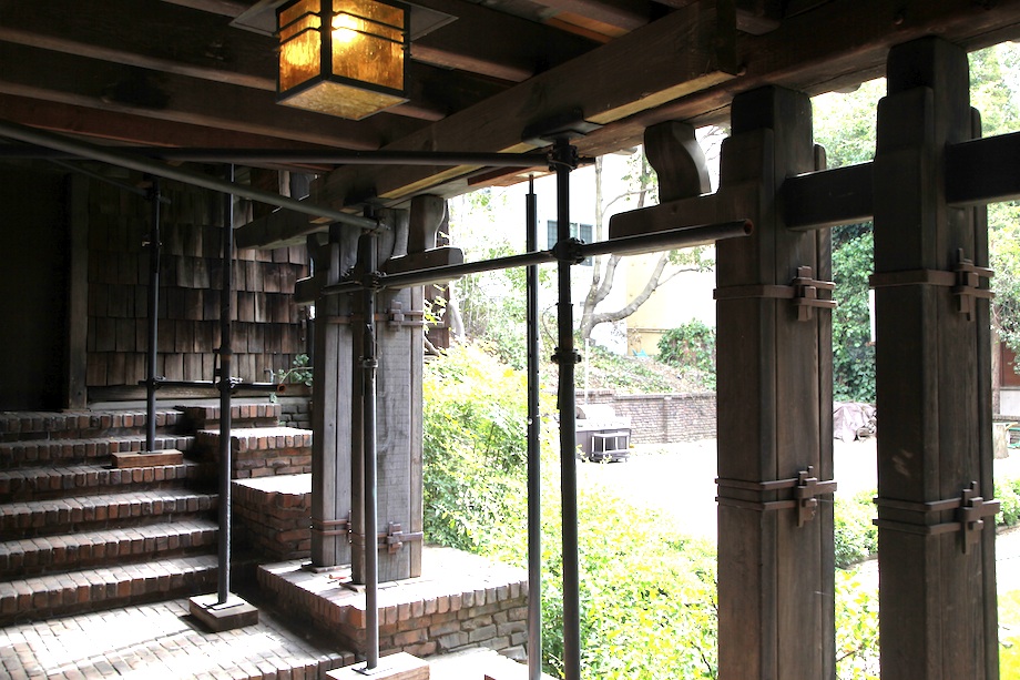 Terrace underpinning with temporary timber supports, clinker brick stairs, and exposed structural beams during restoration