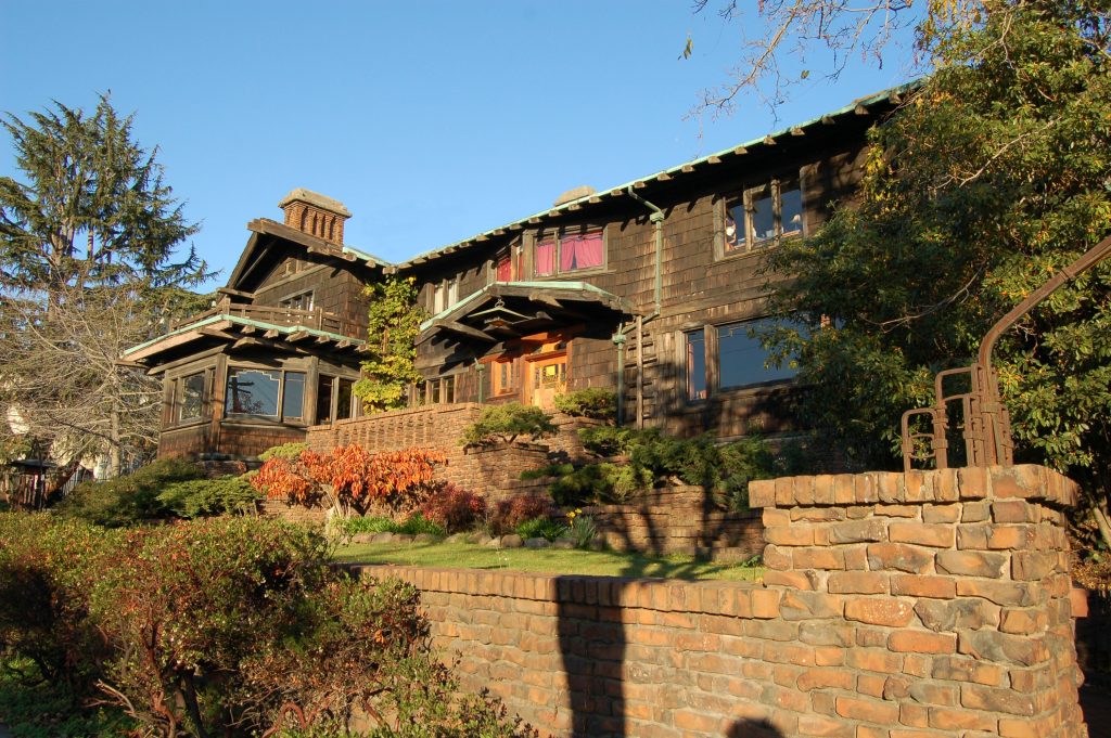 Thorsen House exterior with clinker brick terraces, wood-shingled walls, dramatic rooflines, and copper accents