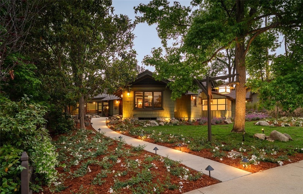 Front walkway of Edgar W. Camp house showing Craftsman bungalow with shingle siding and landscaped garden at dusk