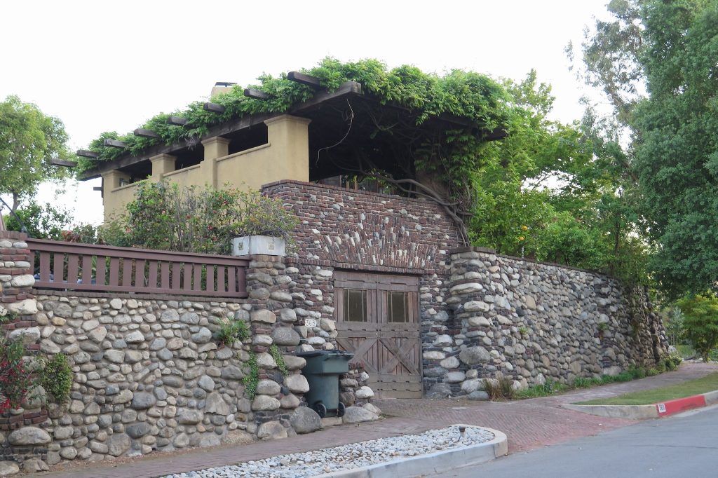 Charles S. Greene House garage designed in clinker brick and cobblestones with wooden pergola structure above