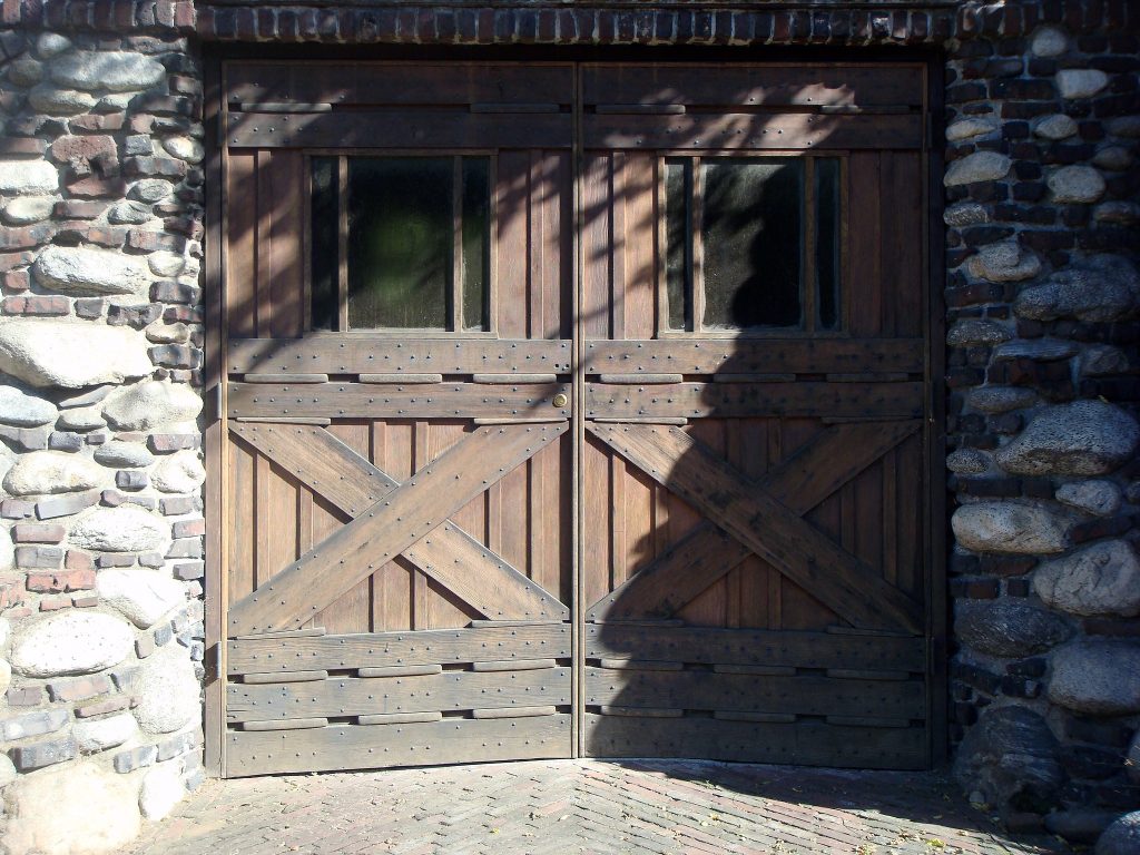 Detailed front view of garage entrance showing clinker brick and cobblestone craftsmanship at Charles S. Greene House