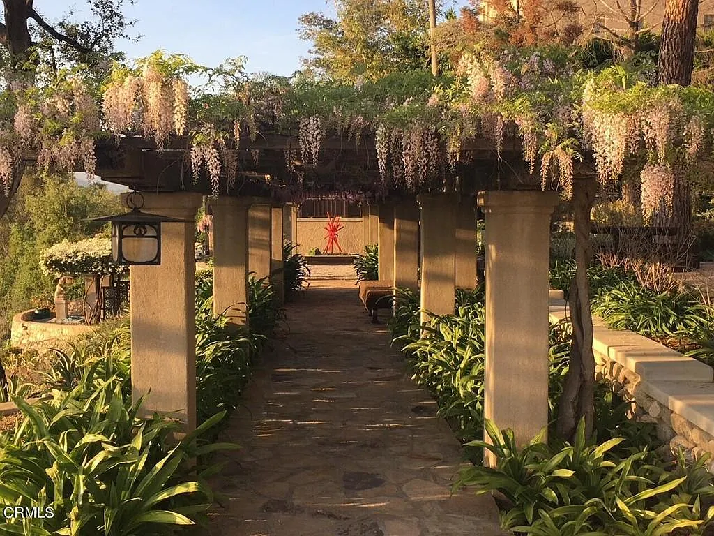 Wisteria-covered pergola at the Laurabelle A. Robinson House with purple blooms, outdoor seating, and canyon vistas