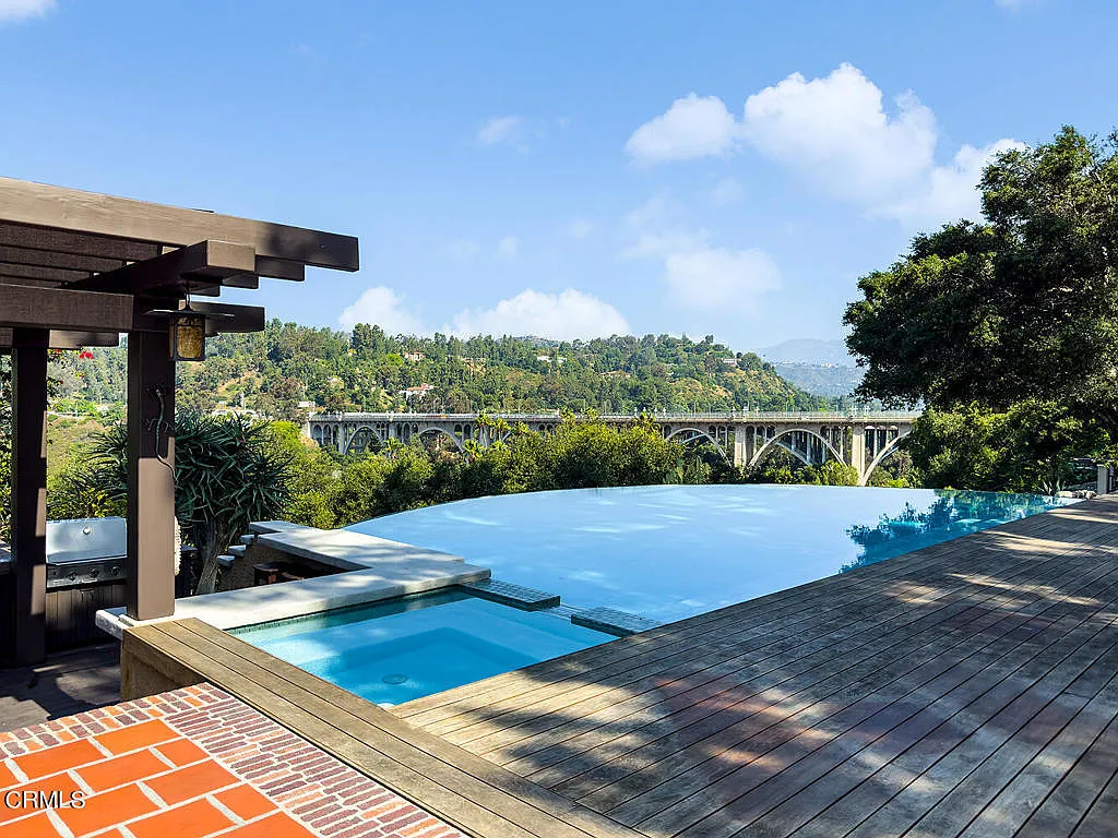 Swimming pool at the Laurabelle A. Robinson House with blue tile, surrounding patio, pergola, and mountain backdrop
