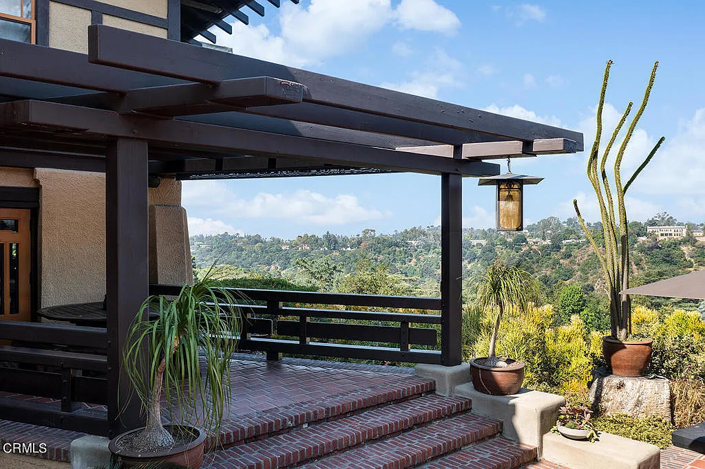 Terrace at the Laurabelle A. Robinson House with stone walls, outdoor furniture, and sweeping views of Arroyo Seco canyon