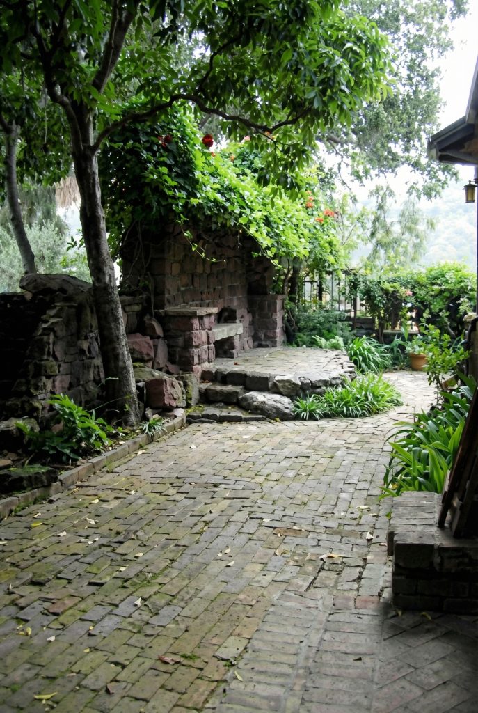 West patio of Charles S. Greene House with brick terrace overlooking Arroyo View Drive, Pasadena, California