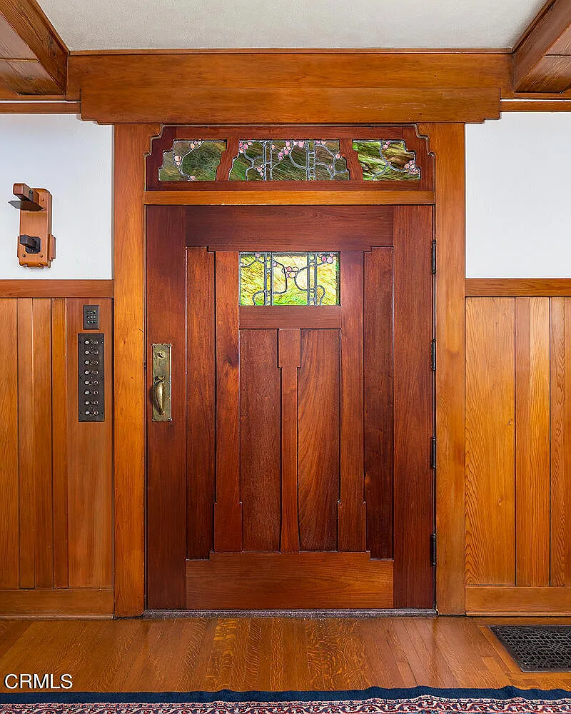 Arts and Crafts front door of the Laurabelle A. Robinson House with decorative hardware, sidelights, and stone entry