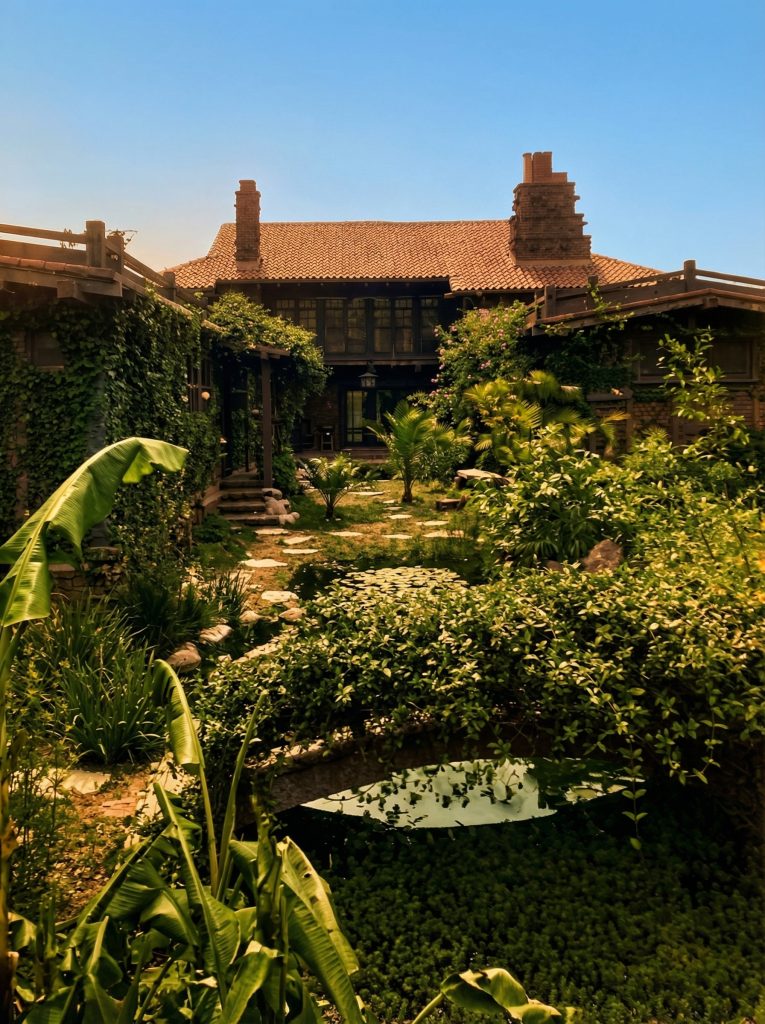 Historic colorized photograph of garden view showing Japanese landscaping design at Adelaide Tichenor house, Long Beach