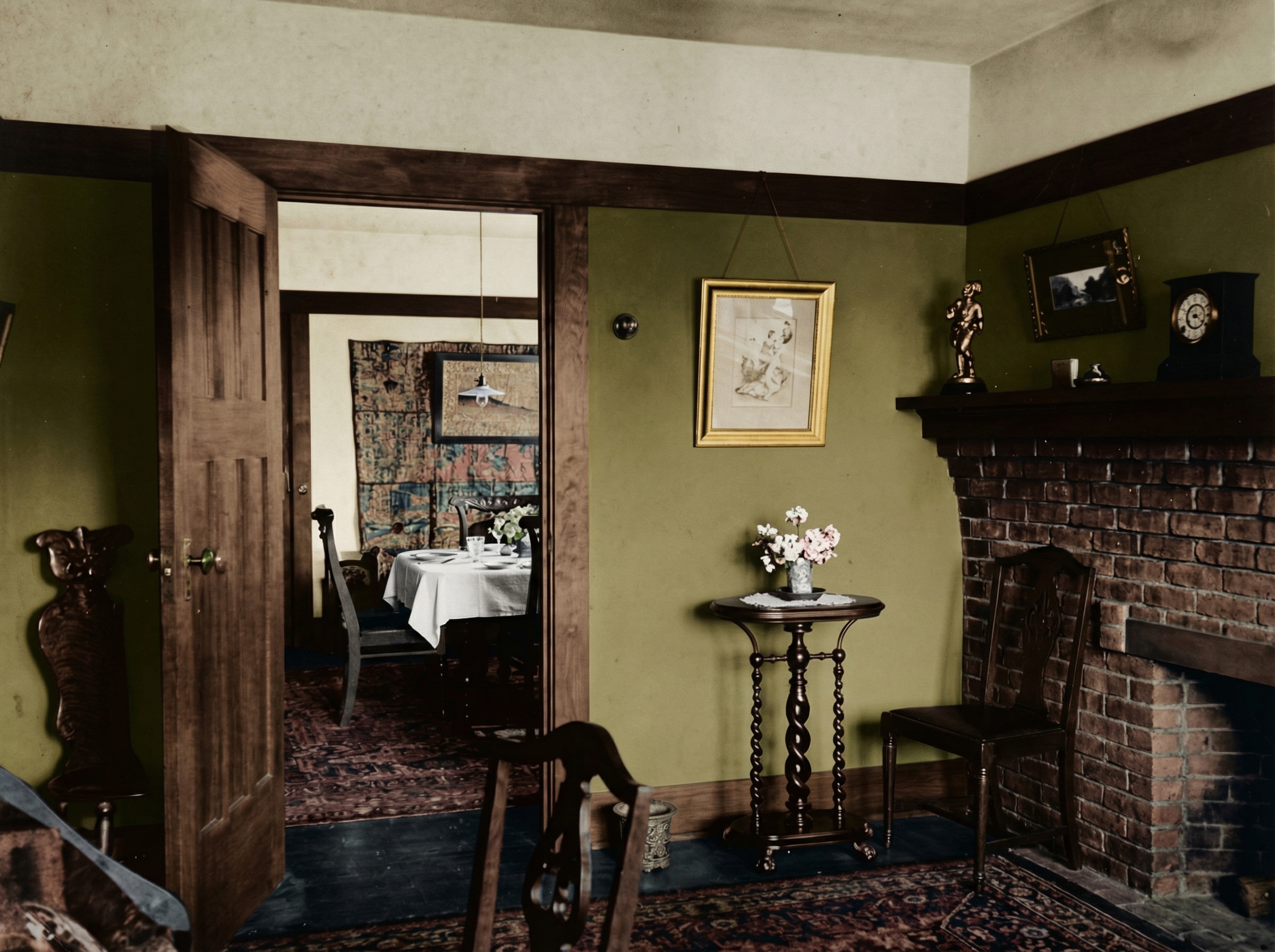 Historic colorized interior photograph of the Mrs. C. A. Whitridge House showing a living room with exposed beam ceiling, brick fireplace, Arts and Crafts furnishings, and the connection to adjacent dining spaces.