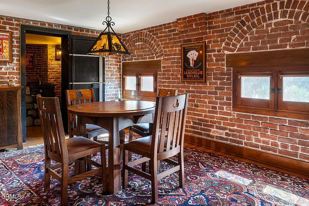 Game room in the Laurabelle A. Robinson House with original brick foundation, Arts & Crafts furniture, and vintage lighting fixtures