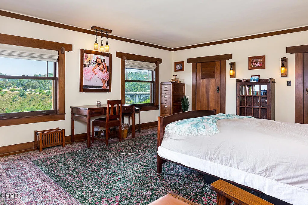 Second bedroom in the Laurabelle A. Robinson House with exposed beams, wood floors, built-ins, and natural lighting