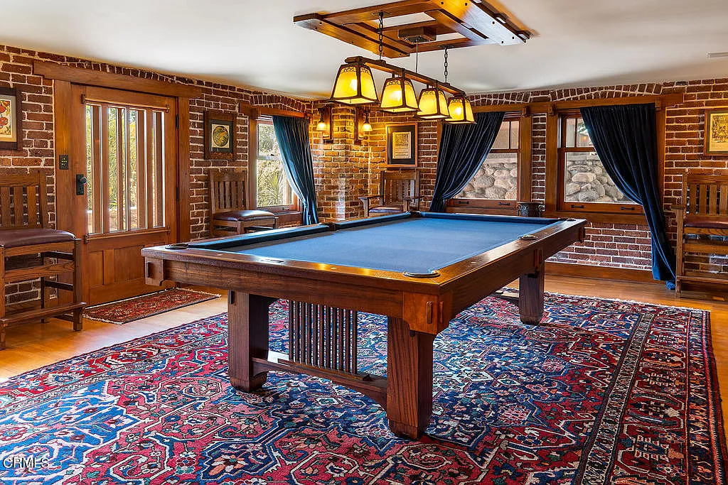 Billiard room in the Laurabelle A. Robinson House with pool table, exposed beams, wood paneling, and Arts and Crafts lighting